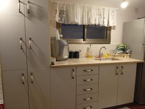 a kitchen with white cabinets and a sink at Alma & Noa in Or ‘Aqīvāh