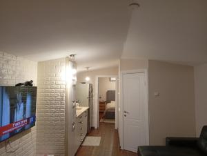 a living room with a couch and a tv on a wall at Alma & Noa in Or ‘Aqīvāh