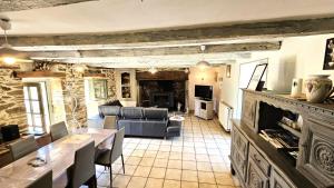 a living room with a couch and a fireplace at Gîte de France Le rouzeyrol 3 épis - Gîte de France 12 personnes MAE-9674 in Charbonniers