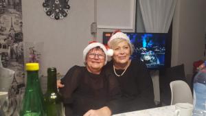 zwei ältere Frauen sitzen an einem Tisch und tragen Weihnachtsmützen in der Unterkunft Camping le Montourey in Fréjus