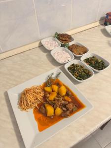 a plate of food on a table with pasta and other dishes at KiDRAK OTEL MONTENEGRO-1 in Faralya