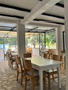a dining room with tables and chairs and windows at KiDRAK OTEL MONTENEGRO-1 in Faralya