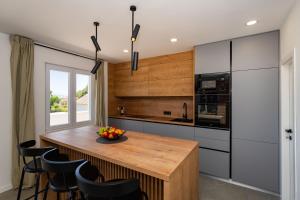 a kitchen with a wooden table and black chairs at MY DALMATIA - Villa Campi Dalmatia with private heated pool and sauna in Galovac