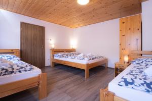 dwa łóżka w pokoju z drewnianą podłogą w obiekcie Apartmenthaus Esther w mieście Ramingstein