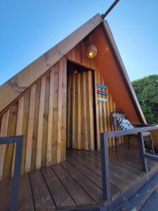 a cabin with a wooden deck with a bench on it at Pousada Praeros in Rifaina