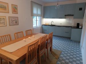 a kitchen with a wooden table and wooden chairs at Dom pod Agatową Skałą we Wleniu in Wleń +26 photos