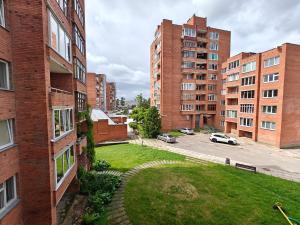 an apartment building with a grassy yard in a city at Holiday Ap in Visaginas