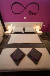 - un lit avec 2 oreillers et un panneau indiquant l'amour dans l'établissement Apartment Andolsek, à Bohinj