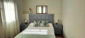a bedroom with a bed with two night stands and a mirror at Casa Saballa in O Grove