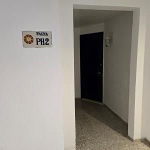 een gang met een zwarte deur en een bord aan de muur bij Mexican Style Top Floor in Cancun