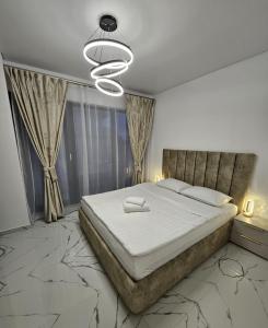 a bedroom with a large bed and a chandelier at EverGreen Apartment4 in Năvodari