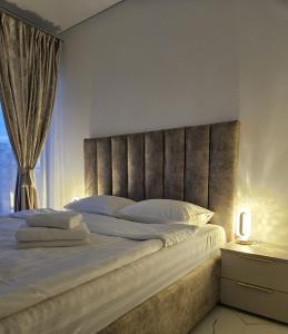a bedroom with a large bed with a large headboard at EverGreen Apartment4 in Năvodari