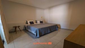a bedroom with a bed and a table in it at Apartamento em Delfinopolis perto das Cachoeiras in Delfinópolis