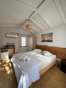 a bedroom with a large white bed with towels on it at KiDRAK OTEL MONTENEGRO-1 in Faralya