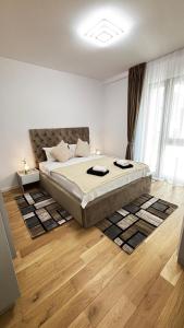 a bedroom with a bed and a wooden floor at Monarch Luxury Apartment in Timişoara