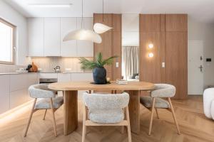 a kitchen with a wooden table and chairs at Leśne spa przy Sopocie in Gdynia