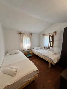 a bedroom with two beds and a window with curtains at KiDRAK OTEL MONTENEGRO-1 in Faralya