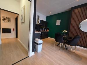 a room with a table and chairs and a green wall at Deluxe 2BR Apartment Near City Center - Sleeps 6 in Liverpool +79 photos