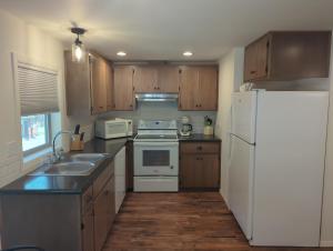 a kitchen with a white refrigerator and wooden cabinets at Eagle Cap Chalets in Joseph