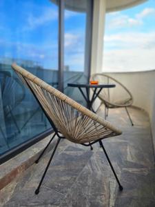 two chairs and a table in front of a window at EverGreen Apartment4 in Năvodari