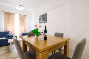 a dining room with a table with a bottle of wine at Apartment with Pool "Sunset Cove" in Neum