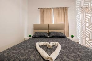a bed with two towels in the shape of a heart at Apartment with Pool "Sunset Cove" in Neum +17 photos