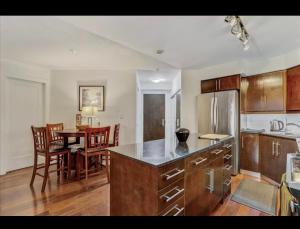 a kitchen and dining room with a table and a refrigerator at Core Downtown Toronto-8 Sleeper-4 Beds-2 Bathrooms-Washrooms-Free Parking-CN Tower-Ripleys Museum-Blue Jays Stadium In front-Indoor Gym-Swimming Pool-Jacuzzi Sauna-Filter Drinking Water-WiFi in Toronto