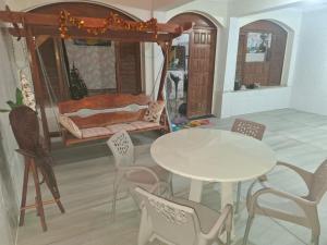 a room with a table and chairs and a bed at CASA Mosqueiro AMAZONIA BELÉM COP 30 in Belém