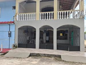 a building with four windows with bars on it at CASA Mosqueiro AMAZONIA BELÉM COP 30 in Belém