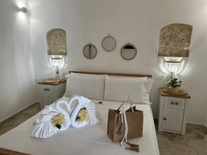 a bedroom with a bed with two bags and two lamps at Godano Rooms in Drapia