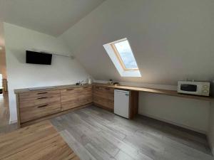 a kitchen with a counter with a microwave and a window at Bądź blisko in Jurków