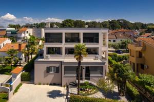 an aerial view of a white house with a palm tree at Maneo Lux in Poreč