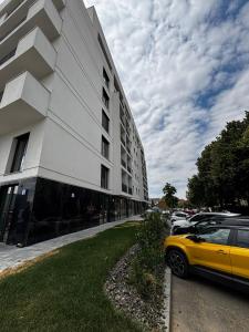 a yellow car parked in front of a building at Monarch Luxury Apartment in Timişoara