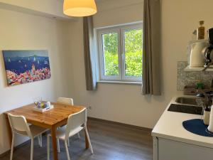 a kitchen with a wooden table and chairs in a kitchen at Natasa apartments Krk in Vrh