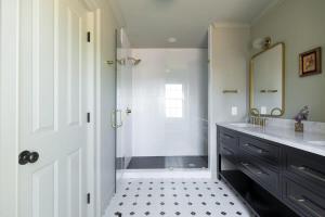 een badkamer met douche, wastafel en spiegel bij The Nicholas Veranda King Suite - Walk to King in Charleston