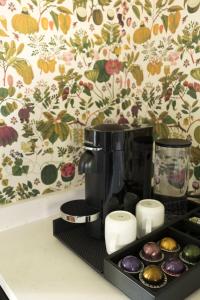 een koffiezetapparaat op een zwarte schaal naast cupcakes bij The Nicholas Veranda King Suite - Walk to King in Charleston