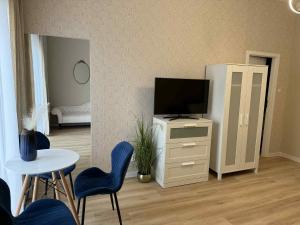 a living room with a television and a table and chairs at Leśna Przystań in Pojezierze +9 photos