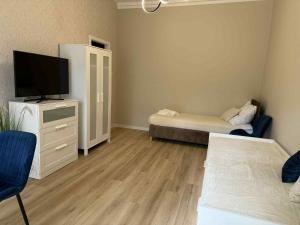 a living room with a tv and a couch at Leśna Przystań in Pojezierze