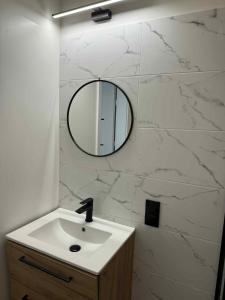 a bathroom with a sink and a mirror on a wall at Leśna Przystań in Przyjezierze