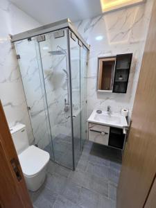 een badkamer met een douche, een toilet en een wastafel bij Luxury Appartement fes city fleur in Fès
