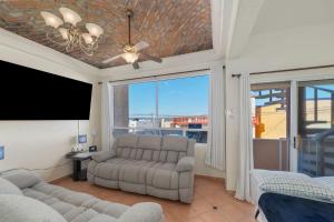 uma sala de estar com um sofá e uma TV de tela plana em 3 Story House 3BR 2BA Rooftop View with Heated Pool em La Choya