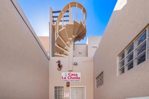 eine Wendeltreppe an der Seite eines Gebäudes mit einem Schild in der Unterkunft 3 Story Home 3BR 2BA with Pool Garage and Rooftop View in La Choya