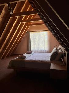 a attic bedroom with a bed with a window at KiDRAK OTEL MONTENEGRO-1 in Faralya