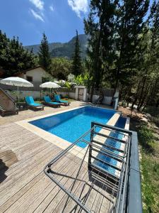 a swimming pool on a deck with chairs and umbrellas at KiDRAK OTEL MONTENEGRO-1 in Faralya