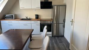 a kitchen with a table and a stainless steel refrigerator at Marlin City Apartment 2 in Bielefeld +12 photos