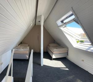 an attic room with two beds and a window at Marlin City Apartment 2 in Bielefeld