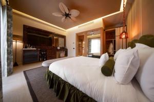 a bedroom with a large white bed with a ceiling fan at Casa Fontana in Alaçatı +37 photos