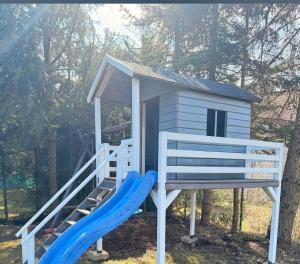 a playground with a slide and a house at Biały Domek Becejły in Becejły