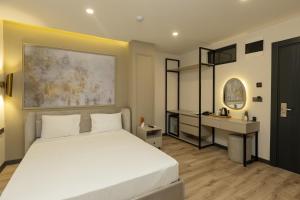 a bedroom with a white bed and a desk at Fora Inn Lara in Antalya