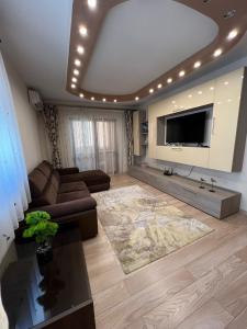 a large living room with a large flat screen tv at Aparthotel Brown in Bucharest